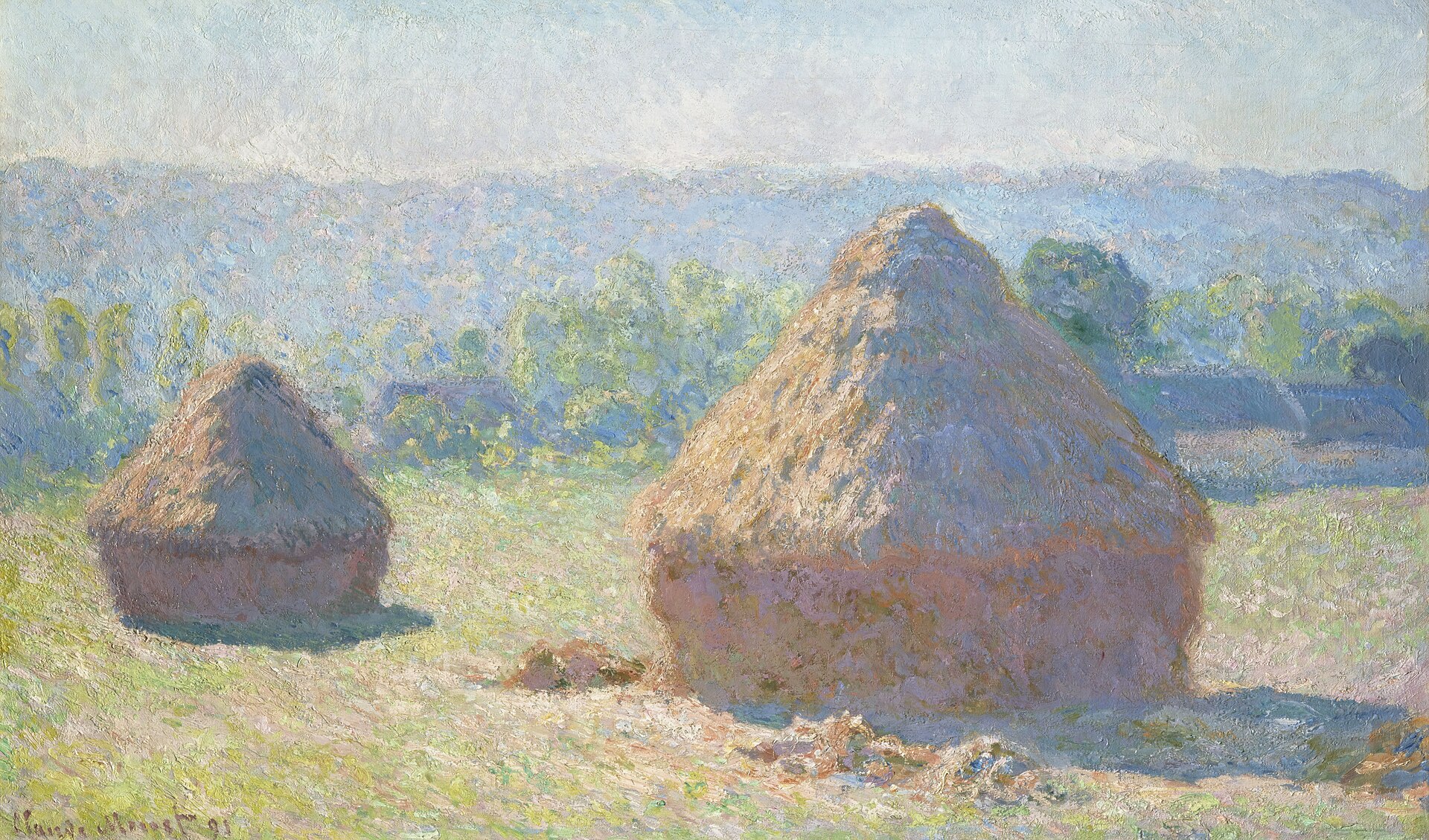 Two haystacks in a field at the end of summer, glowing in warm light against a line of trees and soft hills