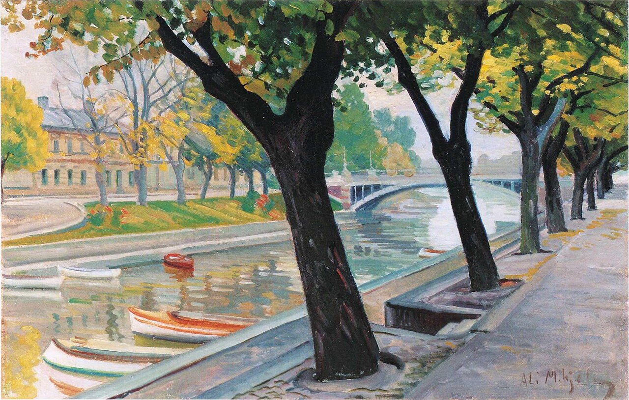 Autumn trees line the stone embankment of the Aura River, with moored rowing boats, a low arched bridge and a pale building on the far bank.