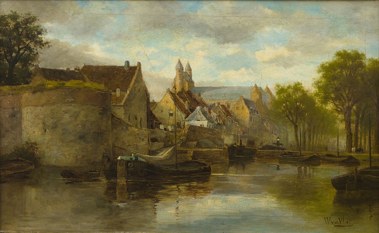 Barges on a calm canal below Maastricht's old city wall and round tower, with gabled houses and the twin turrets of the Onze-Lieve-Vrouwebasiliek behind and a tree-lined quay on the right.